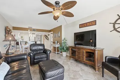 a living room with a couch and a flat screen tv at Dunes of Panama C104 - First Floor Gem in Panama City Beach