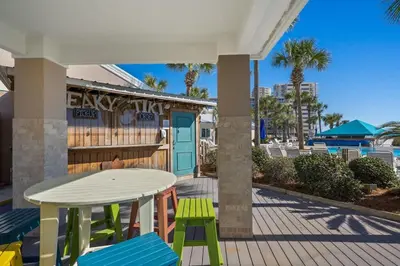 a patio with a table and chairs and a building at Dunes of Panama C104 - First Floor Gem in Panama City Beach