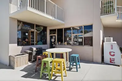 a table and chairs in front of a building at Dunes of Panama C104 - First Floor Gem in Panama City Beach