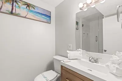 a bathroom with a sink and a toilet and a mirror at The Summit 1419 - Gulf View Escape in Panama City Beach