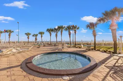 a swimming pool with palm trees and the beach at The Summit 1419 - Gulf View Escape in Panama City Beach