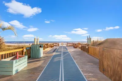 a boardwalk leading to the beach on a sunny day at The Summit 1419 - Gulf View Escape in Panama City Beach