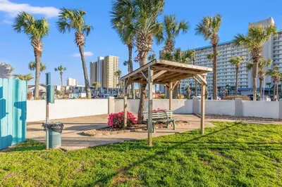 a park with a bench and palm trees at The Summit 1419 - Gulf View Escape in Panama City Beach