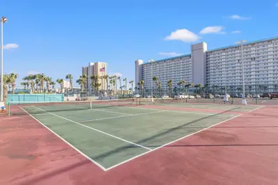 a tennis court in front of a large building at The Summit 1419 - Gulf View Escape in Panama City Beach