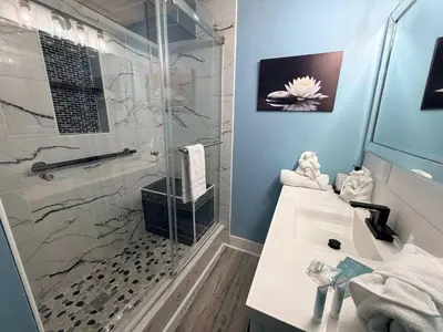a bathroom with a glass shower and a sink at The Summit 1132 - Beachfront Bliss Stunning 2BR in Panama City Beach