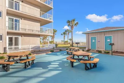 a group of picnic tables and benches in front of a building at The Summit 1132 - Beachfront Bliss Stunning 2BR in Panama City Beach