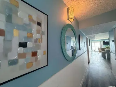 a hallway with a mirror on a wall at The Summit 1132 - Beachfront Bliss Stunning 2BR in Panama City Beach