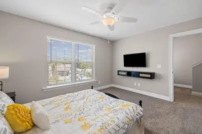 a bedroom with a bed and a flat screen tv at Beach Access - Pool - Game Room - Pets - BBQ Grill in Panama City Beach