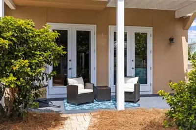 a porch of a home with two chairs and a porch at Beach Access - Pool - Game Room - Pets - BBQ Grill in Panama City Beach