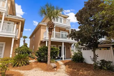 a palm tree in front of a house at Beach Access - Pool - Game Room - Pets - BBQ Grill in Panama City Beach