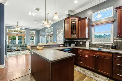 a kitchen with wooden cabinets and a large island at Walk to the Beach - BBQ - Patio - Play Area - Pets in Panama City Beach