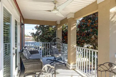 a porch with chairs and a ceiling fan at Walk to the Beach - BBQ - Patio - Play Area - Pets in Panama City Beach
