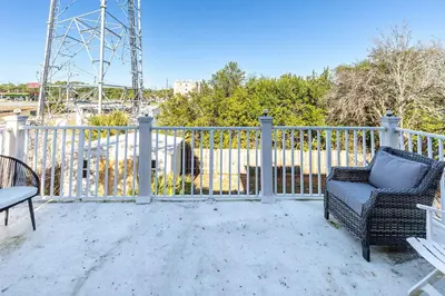 a patio with a chair and a table and a fence at Walk to the Beach - BBQ - Patio - Play Area - Pets in Panama City Beach