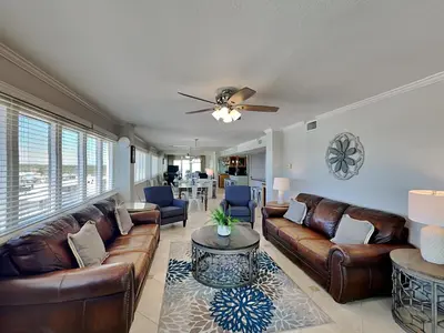 a living room with leather furniture and a ceiling fan at Dunes of Panama #D801 in Panama City Beach