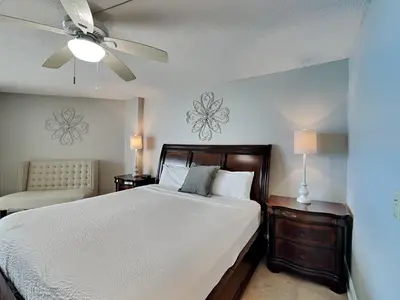 a bedroom with a bed and a ceiling fan at Dunes of Panama #E1405 in Panama City Beach