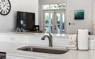 a kitchen with a sink and a clock on the wall at A Villa La La in Santa Rosa Beach