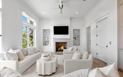 a living room with white furniture and a fireplace at APRÉS 30A in Santa Rosa Beach