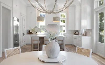 a white kitchen with a table with a vase on it at APRÉS 30A in Santa Rosa Beach