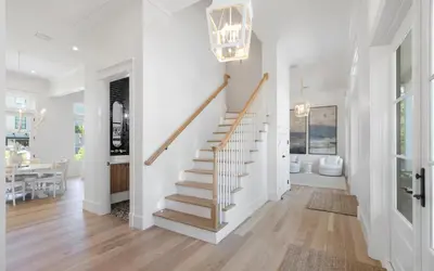 a staircase in a home with white walls and wood floors at APRÉS 30A in Santa Rosa Beach