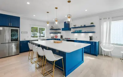 a kitchen with blue cabinets and white countertops at Barsealona in Santa Rosa Beach