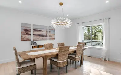 a dining room with a table and chairs and a chandelier at Barsealona in Santa Rosa Beach
