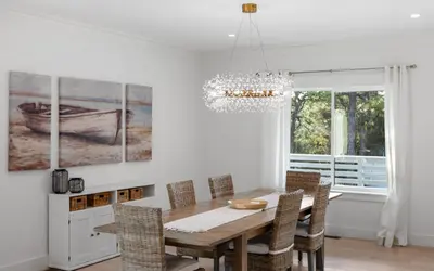 a dining room with a table and chairs and a chandelier at Barsealona in Santa Rosa Beach