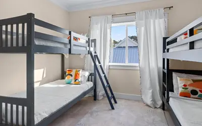 a bedroom with two bunk beds and a window at Barsealona in Santa Rosa Beach