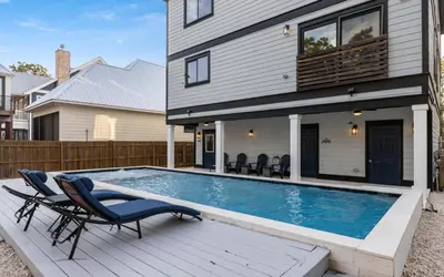 a house with a swimming pool in front of a house at Barsealona in Santa Rosa Beach