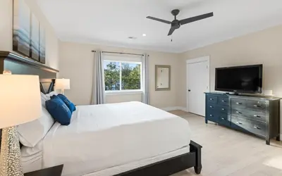 a bedroom with a large bed and a flat screen tv at Barsealona in Santa Rosa Beach