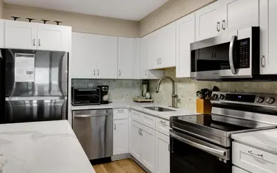 a kitchen with white cabinets and stainless steel appliances at Beachcrest 202 in Santa Rosa Beach
