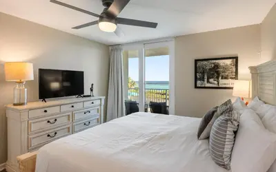 a bedroom with a bed with a television and a dresser at Beachcrest 202 in Santa Rosa Beach