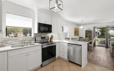 a kitchen with white cabinets and a stove top oven at Beachwood 8G in Santa Rosa Beach