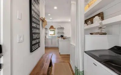 a kitchen with white walls and a wooden table at Cottage Breeze in Rosemary Beach