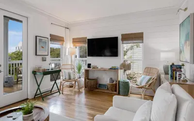 a living room with a couch and a tv at Cottage Breeze in Rosemary Beach