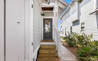 a hallway of a house with a blue door at Cottage Breeze in Rosemary Beach