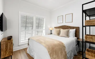 a white bedroom with a bed and a window at Crown Jules in Santa Rosa Beach