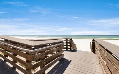 a boardwalk to the beach with the ocean in the background at Crown Jules in Santa Rosa Beach