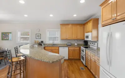 a kitchen with wooden cabinets and a white refrigerator at Ethridge House in Santa Rosa Beach