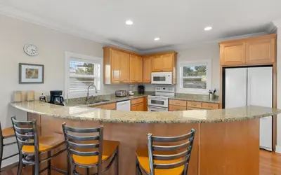a kitchen with wooden cabinets and a large island at Ethridge House in Santa Rosa Beach