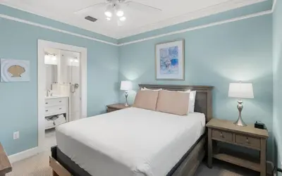 a blue bedroom with a bed and a bathroom at Ethridge House in Santa Rosa Beach