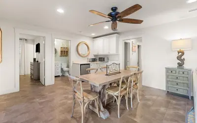a kitchen and dining room with a ceiling fan at Four Palms in Santa Rosa Beach
