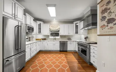 a kitchen with white cabinets and stainless steel appliances at Four Palms in Santa Rosa Beach