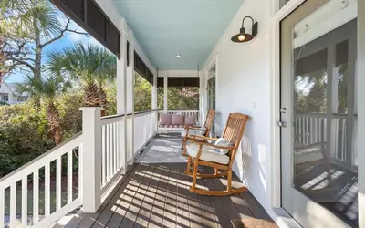 a porch with two rocking chairs on a house at Four Palms in Santa Rosa Beach