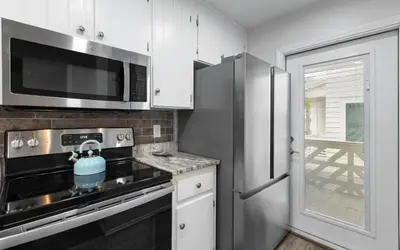 a kitchen with a stove and a microwave at Happy Oasis in Inlet Beach