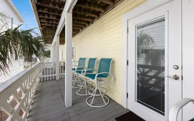 a balcony with blue chairs on a house at Happy Oasis in Inlet Beach