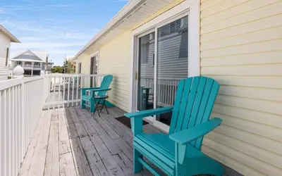 a pair of blue chairs sitting on the porch of a house at Happy Oasis in Inlet Beach