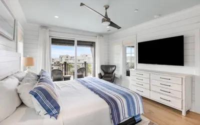 a white bedroom with a tv and a bed at Heaven on Pointe in Santa Rosa Beach