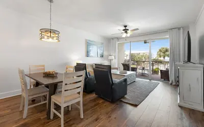 a dining room and living room with a table and chairs at High Pointe Unit 2-223 in Rosemary Beach