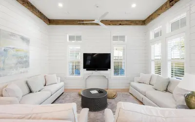 a living room with white furniture and a flat screen tv at Keepin It Reel in Santa Rosa Beach