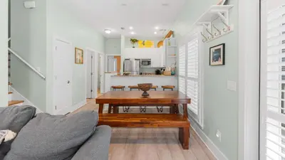 a living room with a table and a kitchen at Lemon Drop House in Seacrest